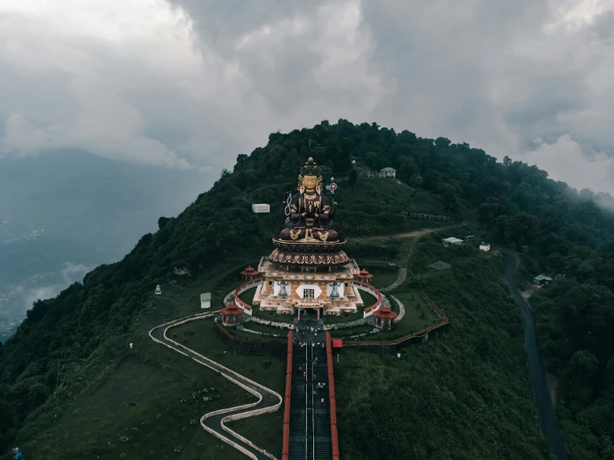 An aerial view of a mountain with a statue on top of it